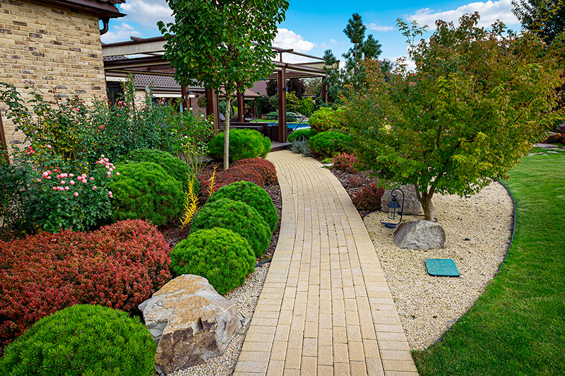 beautifully landscaped yard with a brick walkway
